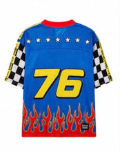 Load image into Gallery viewer, Woman wearing the All American Racing Team oversized mesh jersey featuring blue racing graphics, checkered sleeves, flame details, varsity lettering, and a large number 76 on the back.
