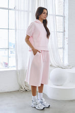 Load image into Gallery viewer, Light pink fleece Bermuda shorts with front pintuck detailing, elastic drawstring waistband, side pockets, relaxed fit, and soft stretch fabric.
