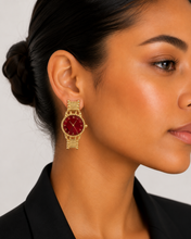 Load image into Gallery viewer, Gold-tone watch-inspired statement earrings with deep crimson watch faces displayed on a model.
