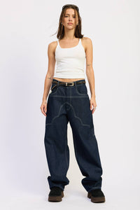 Woman wearing a white tank top and dark blue jeans on a white background