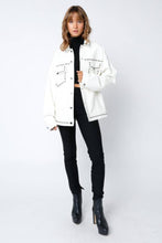 Load image into Gallery viewer, White vegan leather jacket with silver stud detailing, button-front closure, and front pockets, styled over a black top for a modern, edgy look.

