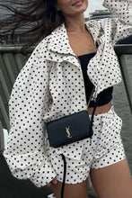 Load image into Gallery viewer, White cropped jacket with black polka dot print, featuring a high collar, long sleeves, and adjustable drawstring hem.
