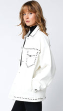 Load image into Gallery viewer, White vegan leather jacket with silver stud detailing, button-front closure, and front pockets, styled over a black top for a modern, edgy look.
