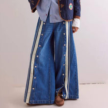 Load image into Gallery viewer, Person wearing a long blue denim jeans with white stripes on a plain background
