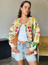 Load image into Gallery viewer, Brighten up any day with our Fruity Knit Cardigan Sweater! This cozy piece features an oversized fit for easy layering, complete with long sleeves and a ribbed hem for that perfect slouchy look. Crafted from a soft, medium-weight jacquard knit, it’s adorned with a playful multi-colored fruit pattern that’s sure to lift your spirits. With a button-up front and hip-length cut, this cardigan is designed for effortless style and comfort—One size truly fits most!
