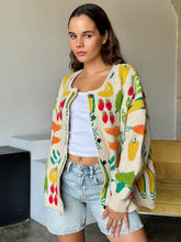 Load image into Gallery viewer, Brighten up any day with our Fruity Knit Cardigan Sweater! This cozy piece features an oversized fit for easy layering, complete with long sleeves and a ribbed hem for that perfect slouchy look. Crafted from a soft, medium-weight jacquard knit, it’s adorned with a playful multi-colored fruit pattern that’s sure to lift your spirits. With a button-up front and hip-length cut, this cardigan is designed for effortless style and comfort—One size truly fits most!
