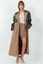 Load image into Gallery viewer, A long brown trench coat featuring a mix of vegan leather and traditional trench materials, offering a unique and chic style. 
