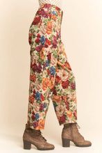 Load image into Gallery viewer, Floral tapestry cargo jogger pants with a high-rise fit, relaxed silhouette, and multicolor vintage-inspired print, styled with ankle boots.
