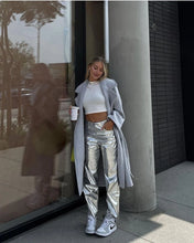 Load image into Gallery viewer, Get ready to shine in our Silver Metallic Pants. These high waisted vegan leather trousers have a straight leg fit, 4 pockets and an amazing iridescent metallic color. These pants are so versatile. They look great teamed with a fitted top and heels for a night out. Or dress them down with a button down shirt, T-shirt or knit sweater. 
