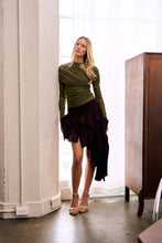 Load image into Gallery viewer, Burgundy asymmetric high-low ruffle skirt with sculptural cascading details styled with a fitted olive green ruched long-sleeve top.
