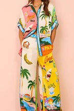Load image into Gallery viewer, Introducing the Paradise Inn Set, featuring a printed short sleeve button-down shirt paired with chic wide-leg matching pants. Designed for comfort, the pants boast a drawstring waist. The vibrant print captures the essence of paradise, with palm trees, flamingos, and tropical colors creating an intoxicating allure. Perfect for those seeking a fun and stylish ensemble.
