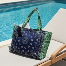 Load image into Gallery viewer, Oversized navy and green cotton canvas tote featuring a patchwork bandana paisley print, green side panels and matching shoulder straps on a white background.

