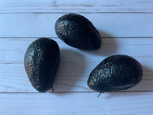 Load image into Gallery viewer, Realistic avocado-shaped coin purse with zipper, keychain ring, and bag charm attachment displayed on a wood background.
