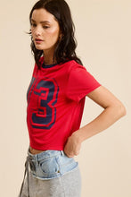 Load image into Gallery viewer, Unleash your sporty side with our Crop Jersey Tee Number 73! This baby tee blends comfort and style, featuring a soft jersey fabric that hugs your body just right. The bold number 73 adds a touch of athletic flair, making it perfect for casual outings or an active day out. Pair it with high-waisted jeans or your favorite shorts for a trendy, effortless look. Elevate your wardrobe with this must-have sporty staple!
