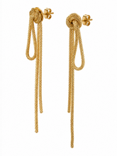 Load image into Gallery viewer, Long gold statement earrings featuring sculptural knot tops with cascading textured chain loops and asymmetrical-length drops.
