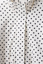 Load image into Gallery viewer, White cropped jacket with black polka dot print, featuring a high collar, long sleeves, and adjustable drawstring hem.
