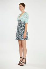 Load image into Gallery viewer, Step into summer with this adorable floral dress, featuring contrasting floral prints for a chic, 90s-inspired look. With its short sleeves, flattering V neckline, and a hem that falls just above the knee, it&#39;s perfect for any warm-weather occasion. Pair it with cowboy boots for a stylish upgrade or keep it casual with your favorite sneakers. Stay cute and on trend all season long!
