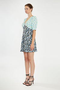 Step into summer with this adorable floral dress, featuring contrasting floral prints for a chic, 90s-inspired look. With its short sleeves, flattering V neckline, and a hem that falls just above the knee, it's perfect for any warm-weather occasion. Pair it with cowboy boots for a stylish upgrade or keep it casual with your favorite sneakers. Stay cute and on trend all season long!