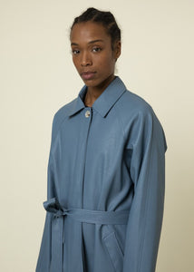 Our butter soft, light blue, vegan leather trench coat has all the standard touches that make a trench coat great like long sleeves, a shirt collar, button closure and a self tie sash belt. This lovely coat is comfortable to wear with full lining and the perfect length. Best of all its retro flair.   Style Tip: Wear our Blue Leather Trench Coat dressed up or down. Our only tip is - never take it off!