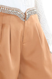 These champagne colored silky shorts are the perfect addition to your wardrobe. The v-cut waist and rhinestone details make this a timeless classic that you are sure to wear again and again. Our Beige Crystal Shorts are excellent quality with pleated pockets and full lining! There is no doubt that you will feel confident and beautiful wearing these dressy shorts. 