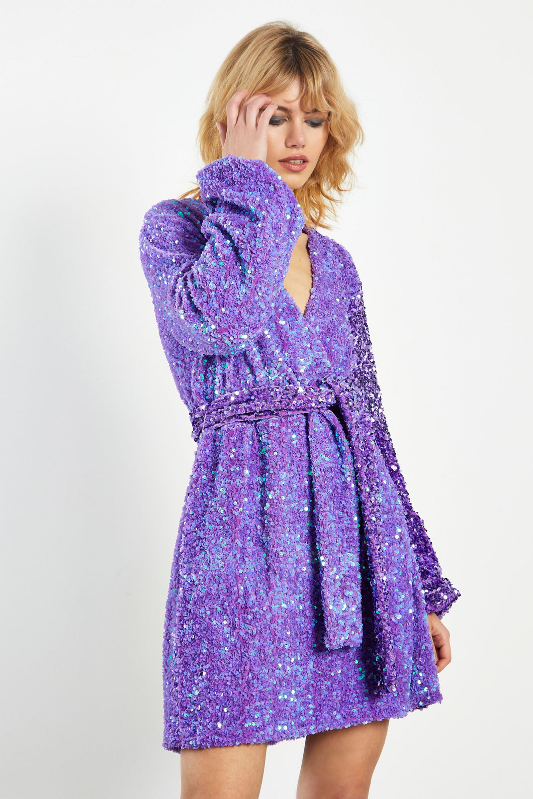 Glam Expressway’s Purple Sequin Dress is chic, feminine and glamorous! This fun sequin dress is fully lined, with a relaxed fit and a self tying belt. This elegant dress has a retro and modern feel at the same time. Wear this glamorous sequin dress when you want to stand out!