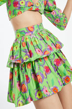 Load image into Gallery viewer, A bright and colorful mini skirt with a flirty ruffle to give you a playful boho look. This green mini skirt features beautiful flowers that burst in every color of the rainbow. This skirt is fun and makes resort wear interesting! Perfect to wear with flats or sandals, it is ultra-comfy with a ruffled hemline. A must-have item for summer vacations and cookouts! Matching top sold separately.
