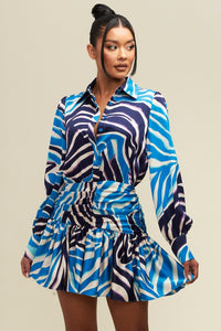 The Blue Ruched Shirt Dress is beautiful and chic with a feminine blue and white pattern, volume sleeves and ruching on the tummy area for a flattering fit. Wear this stylish dress for a fun, flirty and elegant look.