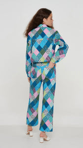 Our fun Patchwork Trousers will brighten up your life. Slightly cropped denim printed trousers with a blue, pink, lavender and green patchwork design have a straight leg fit. Matching shacket sold separately. This set was made from recycled fabrics! Dress them up or down!